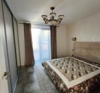 Ein Schlafzimmer in einem Einfamilienhaus mit einem großen Bett, Schränken und einem eleganten Kronleuchter.