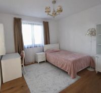 Schlafzimmer in einem Einfamilienhaus mit Bett, Schreibtisch und Boden mit Holzdekor.
