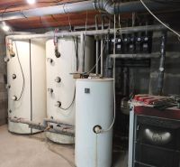 Technische Anlage in einem Einfamilienhaus mit Boiler und Kessel, Rohrleitungen durch den Raum.
