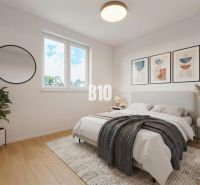 Schlafzimmer mit Bett, Holzboden, Pflanze und rundem Spiegel in einem Einfamilienhaus.