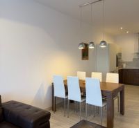 Esstisch mit Stühlen und Boden mit Holzdekor in einer 3-Zimmer-Wohnung.