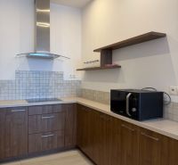 Küche in einer 3-Zimmer-Wohnung mit Holzdekor und eingebauten Geräten.