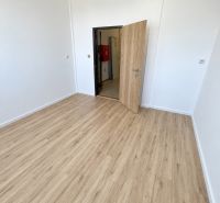Ein Büro mit weißen Wänden und einem Boden in Holzoptik.