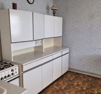 Eine Küche in einem Einfamilienhaus mit einem Gasherd und einem Boden in Holzoptik.