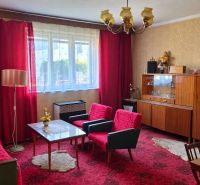 Wohnzimmer in einem Einfamilienhaus mit roten Vorhängen und Vintage-Möbeln.