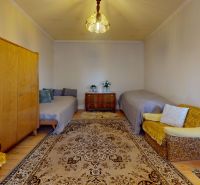 Wohnzimmer in einem Einfamilienhaus mit weichem Teppich, Schrank und zwei Sofas.