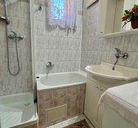 Badezimmer in einem Einfamilienhaus mit Badewanne, Dusche und Waschbecken.
