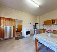 Küche mit Esstisch in einem Einfamilienhaus mit Holzdekor auf dem Boden.