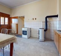 Eine Küche in einem Einfamilienhaus mit einem Esstisch, einem Herd und Holzschränken.