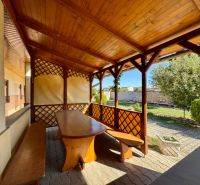 Die Terrasse des Einfamilienhauses in Nadlice mit Holzsitzgelegenheiten und Blick in den Garten.