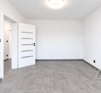 Ein leerer Raum in einer Zweizimmerwohnung mit Keramikboden und weißen Wänden.