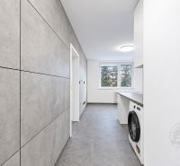 Küche in einer 2-Zimmer-Wohnung mit Fliesenboden und Blick durch ein großes Fenster.