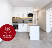 Küche in einer 2-Zimmer-Wohnung mit weißen Schränken und grauem Boden.