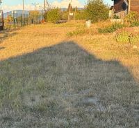 Der Garten beim Einfamilienhaus in Blatné Revištia mit Rasenbewuchs und Himmel im Hintergrund.