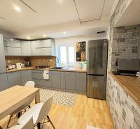Eine Küche in einem Einfamilienhaus mit einem Boden in Holzoptik, ausgestattet mit moderner Technik.