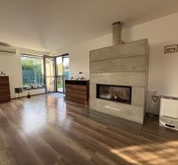 Wohnzimmer in einem Einfamilienhaus mit Kamin und Holzboden.