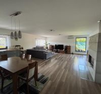 Wohnzimmer in einem Einfamilienhaus mit Holzboden, Kamin und Esstisch.