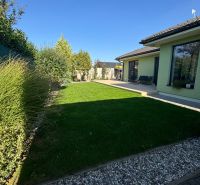 Garten beim Einfamilienhaus in der Figová-Straße in Bernolákovo mit Rasen und Terrasse.