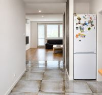 Innenraum einer 3-Zimmer-Wohnung mit Holzboden und Keramik, Wohnzimmer im Hintergrund.