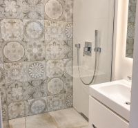 Duschkabine mit dekorativen Fliesen im Badezimmer einer 3-Zimmer-Wohnung.