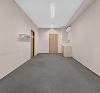 Büros mit Teppichboden und kleiner Küche, ein einfacher Raum für Arbeit oder Treffen.