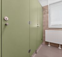 Grüne Türen in Büros, Heizkörper und Fenster mit Rollladen.