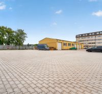 Parkplatz und gelbes Gebäude in der Brnianska Straße in Trenčín, geeignet für Büros.