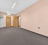 Im Büro gibt es ein Waschbecken, zwei Türen und helle Wände.