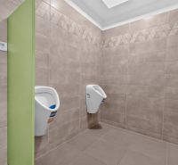 Innenraum eines Büros mit Wandverkleidung und zwei Urinalen.