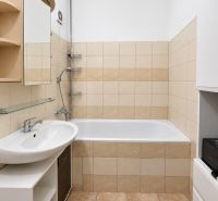 Badezimmer mit Badewanne, Waschbecken und Keramikfliesen in einer 4-Zimmer-Wohnung.
