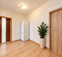 Diele in einer 3-Zimmer-Wohnung mit Holzboden und einem weißen Kühlschrank.