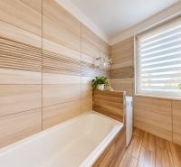 Badezimmer mit Badewanne und Fenster, Boden mit Holzdekor, 3-Zimmer-Wohnung.