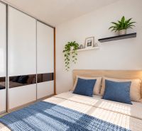 Helles Schlafzimmer in einer 3-Zimmer-Wohnung mit großem Schrank und Pflanzendekor.