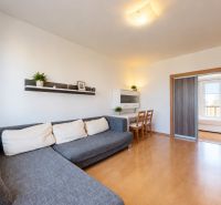 Wohnzimmer in einer 3-Zimmer-Wohnung mit Ecksofa und Schiebetüren.