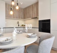 Esszimmer in einer 4-Zimmer-Wohnung mit rundem Tisch und Boden mit Holzdekor.