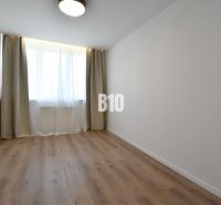 Ein Zimmer mit Vorhängen und einem Boden in Holzoptik in einer 4-Zimmer-Wohnung.