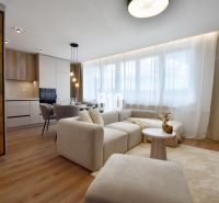 Wohnzimmer mit heller Couch, Essbereich und Küche in einer 4-Zimmer-Wohnung.
