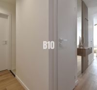 Innenraum einer 4-Zimmer-Wohnung mit Holzboden und minimalistischen Möbeln.
