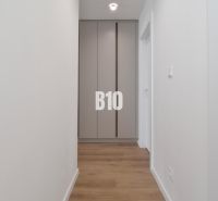 Flur mit Einbauschrank und Boden mit Holzdekor in einer 4-Zimmer-Wohnung.