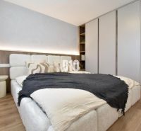 Schlafzimmer in einer 4-Zimmer-Wohnung mit Bett, Einbauschrank und Bodenbelag in Holzoptik.