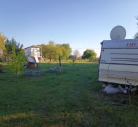 Ein Wohnwagen in den Gärten auf der Tatranská 201 in Zlaté Moravce, umgeben von Bäumen und Gras.