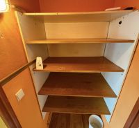 Ein Regal mit vier Holzböden in einer Einzimmerwohnung, Boden mit Holzdekor.