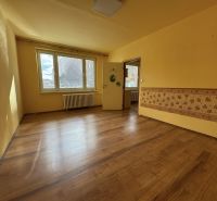 Ein Zimmer mit Holzboden in einer Einzimmerwohnung und gelben Wänden.