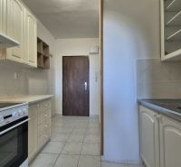 Kochnische in einer Einzimmerwohnung mit weißer Küchenzeile und Keramikboden.