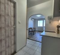 Einzimmerwohnung mit Küche und Holzboden, die zum Esszimmer führt.
