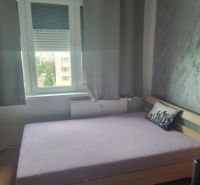 Schlafzimmer in einer 3-Zimmer-Wohnung mit Bett und grauem Dekokissen.