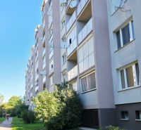 Außenbereich eines Plattenbaus in Trnava mit Grünflächen und einem Gehweg zu einer 3-Zimmer-Wohnung.