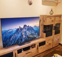 Wohnzimmer mit Fernseher, dekorativen Möbeln und Holzboden in einer 3-Zimmer-Wohnung.