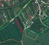 Luftaufnahme von landwirtschaftlichen und forstwirtschaftlichen Flächen in Podhájska mit sichtbarem Straßennetz.