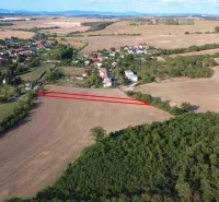 Luftaufnahme von landwirtschaftlichen und forstwirtschaftlichen Flächen in Podhájska, umgeben von einem Dorf und Natur.